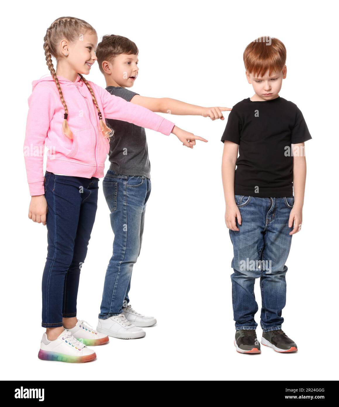 Kinder zeigen auf einen aufgebrachten Jungen auf weißem Hintergrund. Kindermobbing Stockfoto