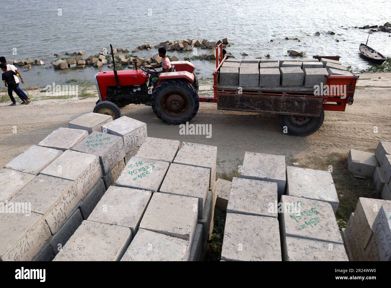 Louhajung, Munshigonj, Bangladesch. 17. Mai 2023. Der Fluss Padma ist ein sehr erosiver Fluss. Die Arbeiter tragen Betonblöcke mit einem Gewicht von 160 kg, um einen Damm zu bauen, der den Einsturz des Ufers des Padma in Louhajung upazila in Munshiganj verhindert. (Kreditbild: © Syed Mahabubul Kader/ZUMA Press Wire) NUR REDAKTIONELLE VERWENDUNG! Nicht für den kommerziellen GEBRAUCH! Stockfoto