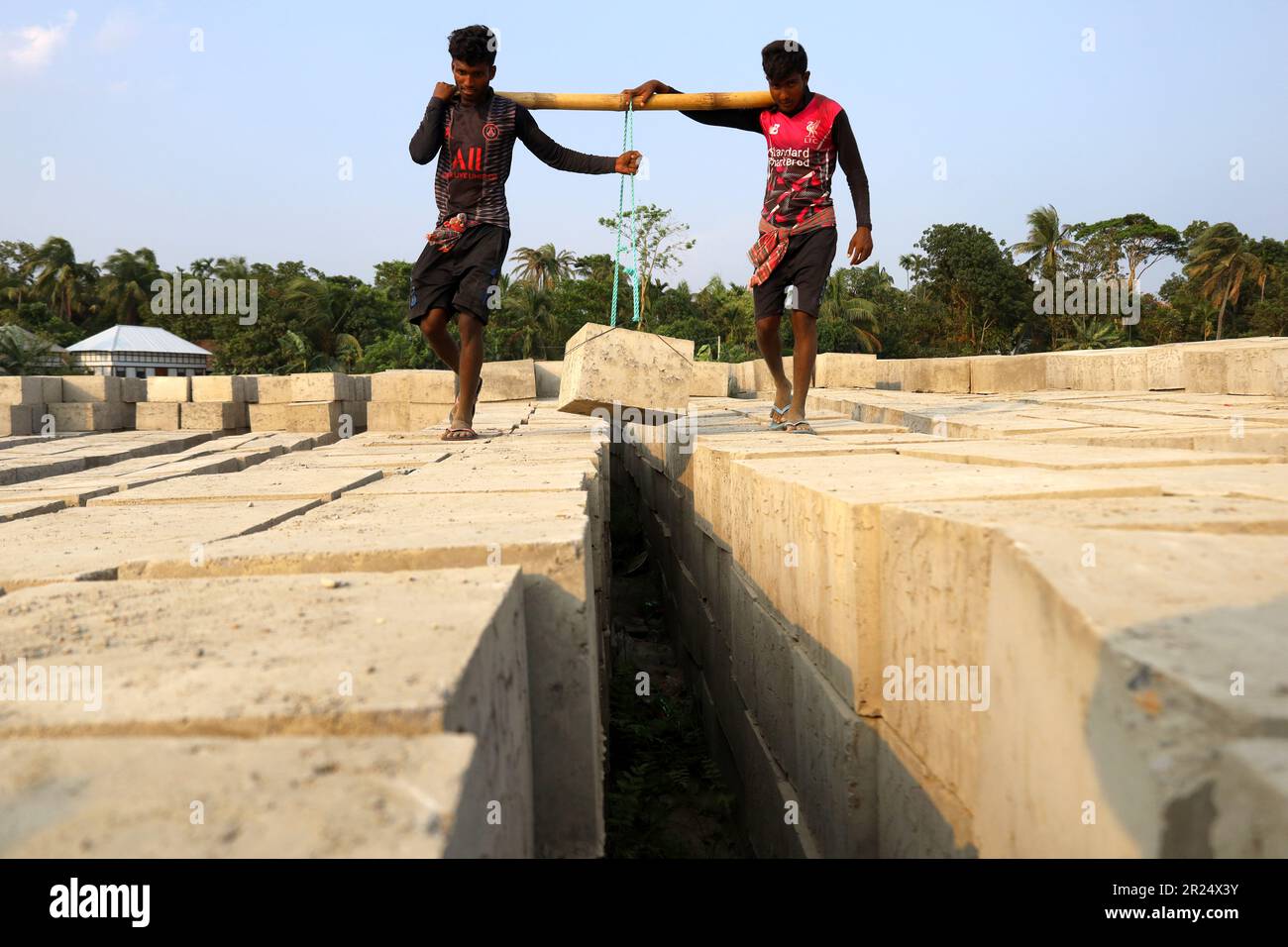 Louhajung, Munshigonj, Bangladesch. 17. Mai 2023. Der Fluss Padma ist ein sehr erosiver Fluss. Die Arbeiter tragen Betonblöcke mit einem Gewicht von 160 kg, um einen Damm zu bauen, der den Einsturz des Ufers des Padma in Louhajung upazila in Munshiganj verhindert. (Kreditbild: © Syed Mahabubul Kader/ZUMA Press Wire) NUR REDAKTIONELLE VERWENDUNG! Nicht für den kommerziellen GEBRAUCH! Stockfoto