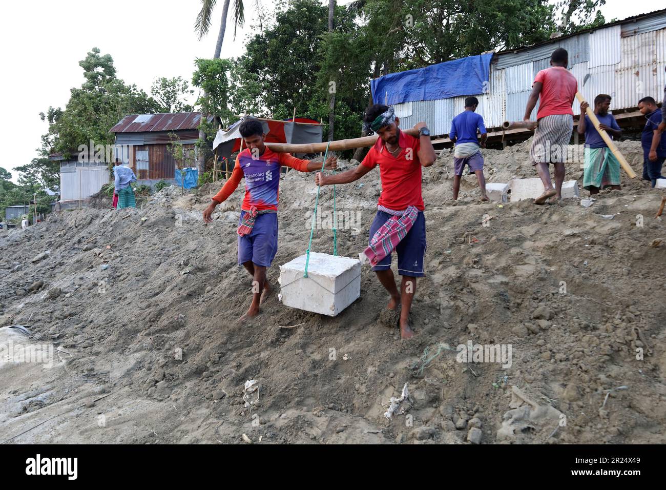 Louhajung, Munshigonj, Bangladesch. 17. Mai 2023. Der Fluss Padma ist ein sehr erosiver Fluss. Die Arbeiter tragen Betonblöcke mit einem Gewicht von 160 kg, um einen Damm zu bauen, der den Einsturz des Ufers des Padma in Louhajung upazila in Munshiganj verhindert. (Kreditbild: © Syed Mahabubul Kader/ZUMA Press Wire) NUR REDAKTIONELLE VERWENDUNG! Nicht für den kommerziellen GEBRAUCH! Stockfoto