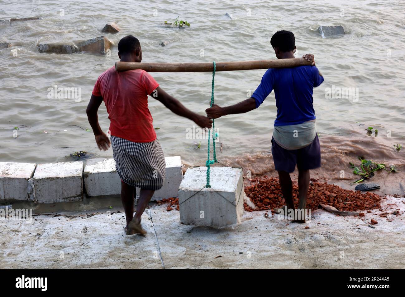 Louhajung, Munshigonj, Bangladesch. 17. Mai 2023. Der Fluss Padma ist ein sehr erosiver Fluss. Die Arbeiter tragen Betonblöcke mit einem Gewicht von 160 kg, um einen Damm zu bauen, der den Einsturz des Ufers des Padma in Louhajung upazila in Munshiganj verhindert. (Kreditbild: © Syed Mahabubul Kader/ZUMA Press Wire) NUR REDAKTIONELLE VERWENDUNG! Nicht für den kommerziellen GEBRAUCH! Stockfoto