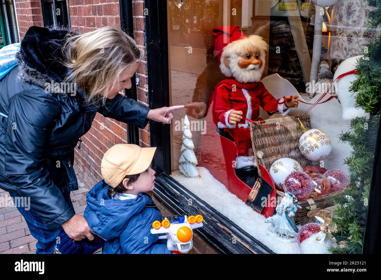 Ein Kind und seine Großmutter schauen sich Ein Schaufenster in Sussex, Großbritannien an Stockfoto