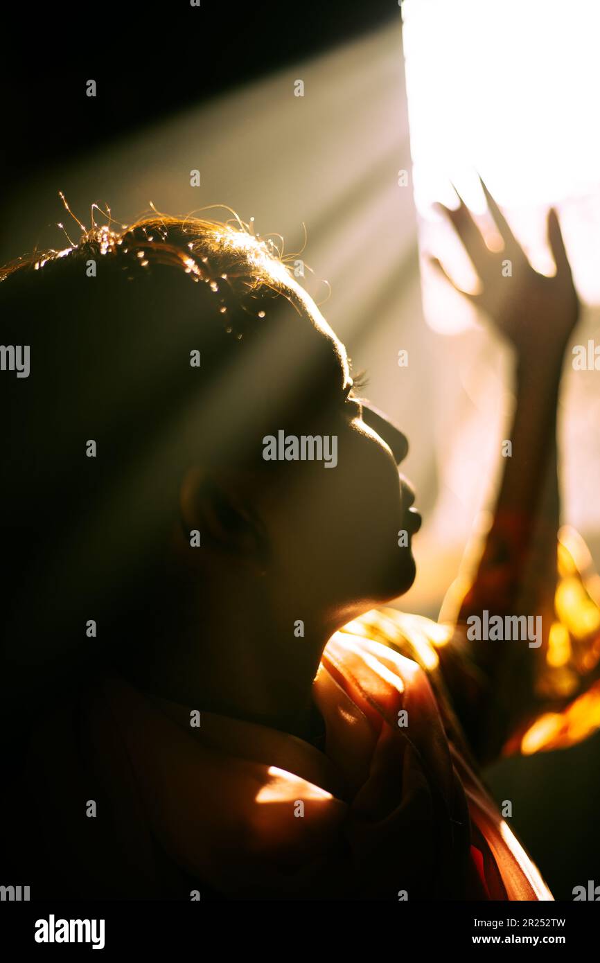 Ein Mädchen, das die warme Atmosphäre des Morgenlichts spürt Stockfoto