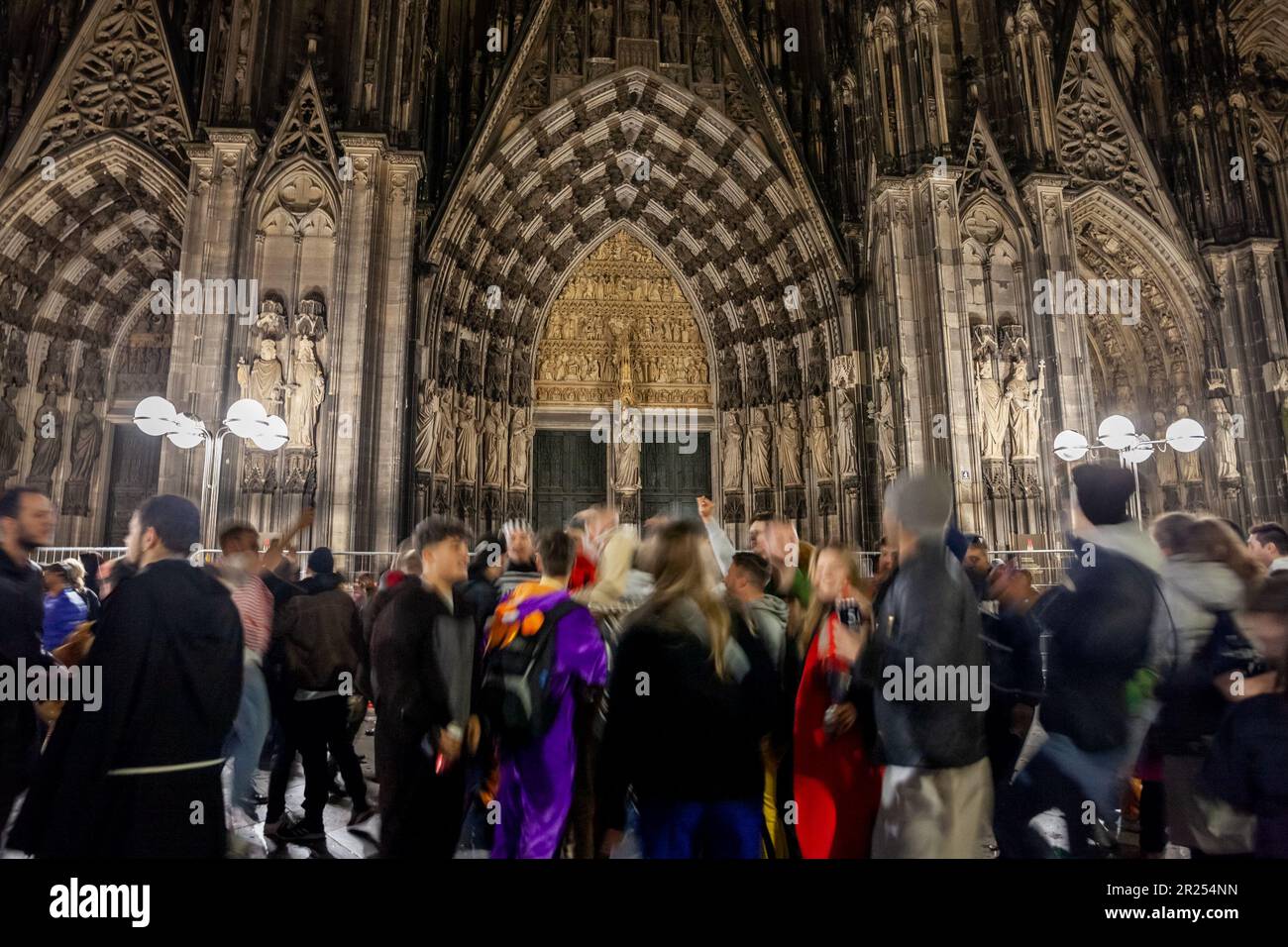 Bild vom Eingang zum kölner Dom mit Menschen, die während des kölner Karnevals vor ihm tanzen. Der Kölner Dom ist katholisch Stockfoto