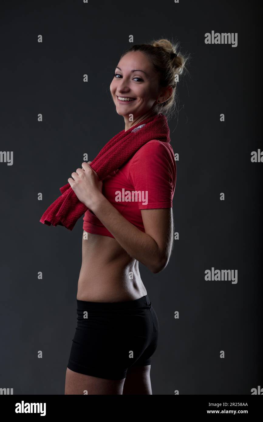 Porträt eines attraktiven Mädchens in Sportkleidung, stolz auf ihren flachen Bauch und festen Hintern. Ein rotes Oberteil und enge schwarze Hosen. Wenn ich einen zu schätzen weiß Stockfoto