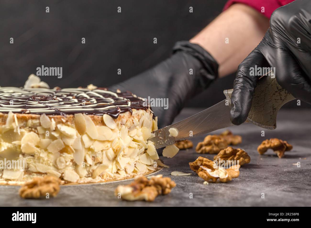 Esterhazy-Kuchen. Kuchendekoration. Schokoladenglasur. Vom Küchenchef dekorierter Kuchen. Der Konditor schmiert flüssige Schokoladenglasur. Hausgemachtes Backkonzept Stockfoto