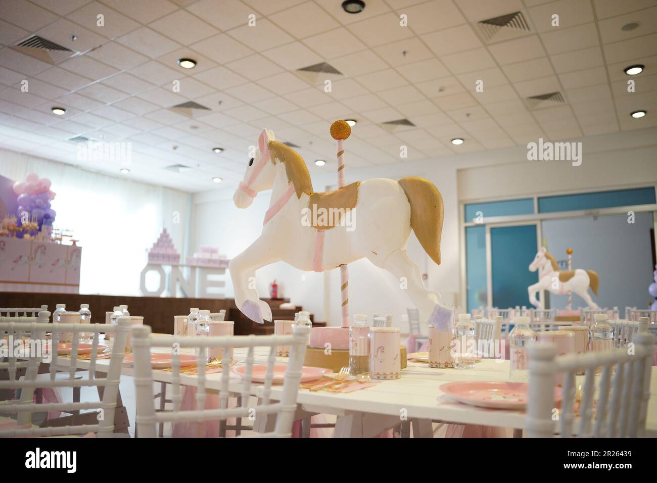 Kindergeburtstagsparty Pferdedekoration. Karussell-Party in Weiß, Pink und Gold mit Mittagstisch. Festliche Dekoration für die Geburtstagsparty eines kleinen Mädchens Stockfoto