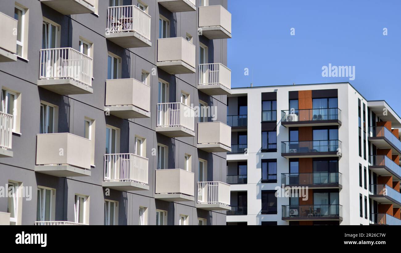 Apartmentgebäude mit hellen Fassaden. Moderne, minimalistische Architektur mit vielen quadratischen Glasfenstern und Balkonen. Stockfoto