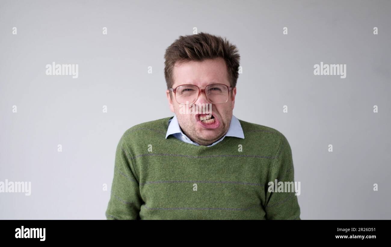 Der europäische junge Mann ist mit dem Ergebnis unzufrieden, er wird wütend und schürt eine grimmige Aggression Stockfoto