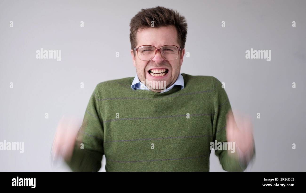 Der europäische junge Mann ist mit dem Ergebnis unzufrieden, er wird wütend und schürt eine grimmige Aggression Stockfoto