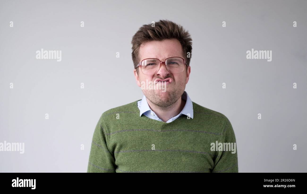 Der europäische junge Mann ist mit dem Ergebnis unzufrieden, er wird wütend und schürt eine grimmige Aggression Stockfoto