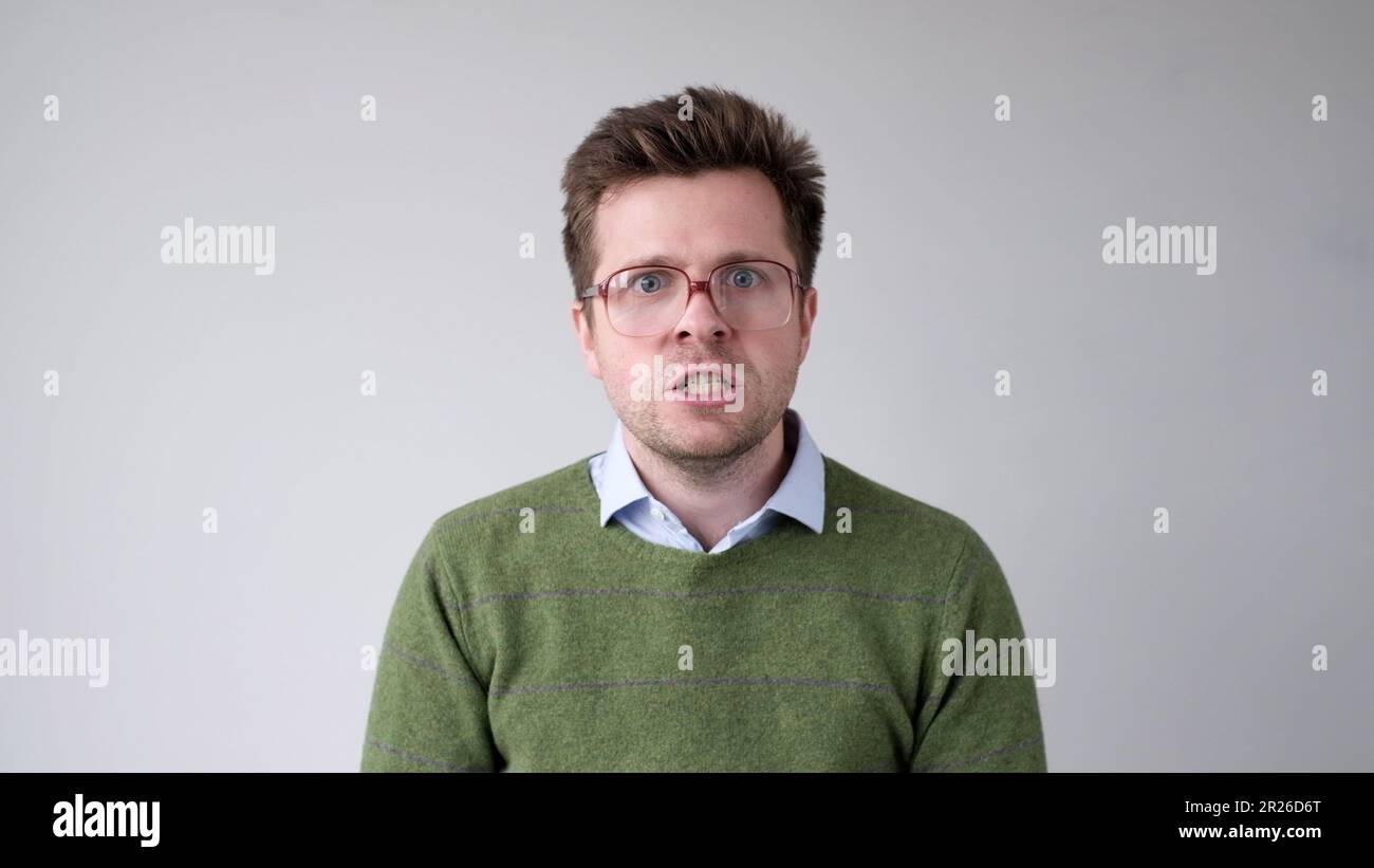 Der europäische junge Mann ist mit dem Ergebnis unzufrieden, er wird wütend und schürt eine grimmige Aggression Stockfoto