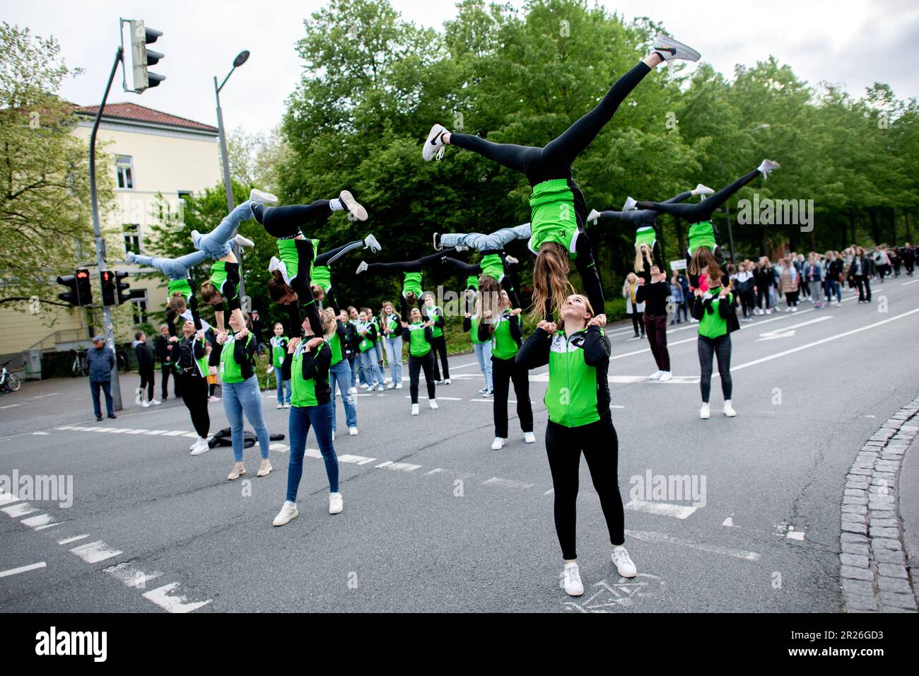 Oldenburg, Deutschland. 17. Mai 2023. Die Akrobatikgruppe „Green Spirits“ von TSG Hatten-Sandkrug nimmt an einer Prozession durch das Stadtzentrum Teil. Das Erlebnis Turnfest 2023 in Oldenburg hat mit einer Prozession und einer Eröffnungszeremonie im Stadtzentrum begonnen. Bis zum 21. Mai 2023 findet die größte Sportveranstaltung in Norddeutschland mit rund 10.000 Teilnehmern statt. Kredit: Hauke-Christian Dittrich/dpa/Alamy Live News Stockfoto