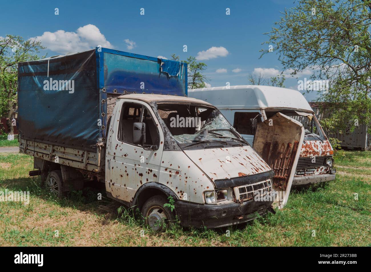 Dorf Knyazevka, Region Kherson, Ukraine - 05-15-2023: Durch Artilleriefeuer beschädigter Bus und LKW. Krieg in der Ukraine. Russische Invasion der Ukraine Stockfoto