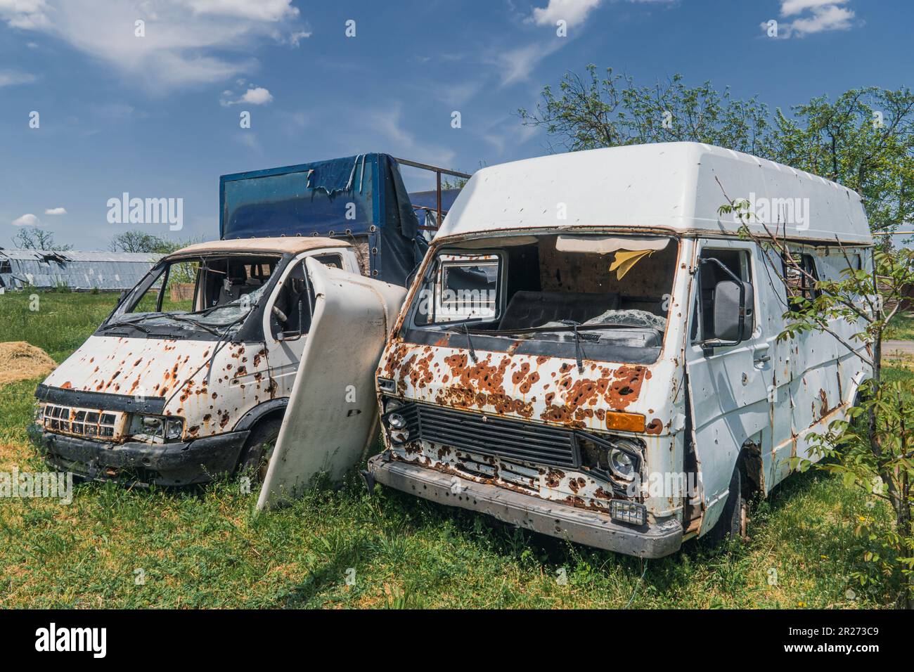 Dorf Knyazevka, Region Kherson, Ukraine - 05-15-2023: Durch Artilleriefeuer beschädigter Bus und LKW. Krieg in der Ukraine. Russische Invasion der Ukraine Stockfoto