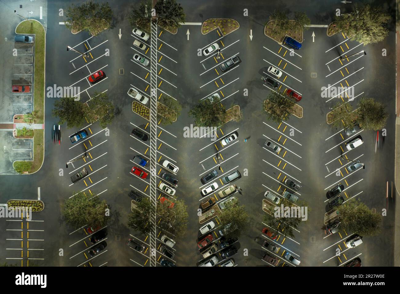 Blick aus der Vogelperspektive auf einen großen Parkplatz bei Nacht mit vielen geparkten Autos. Dunkler Parkplatz im Supercenter-Einkaufszentrum mit Linien und Markierungen für das Fahrzeug Stockfoto