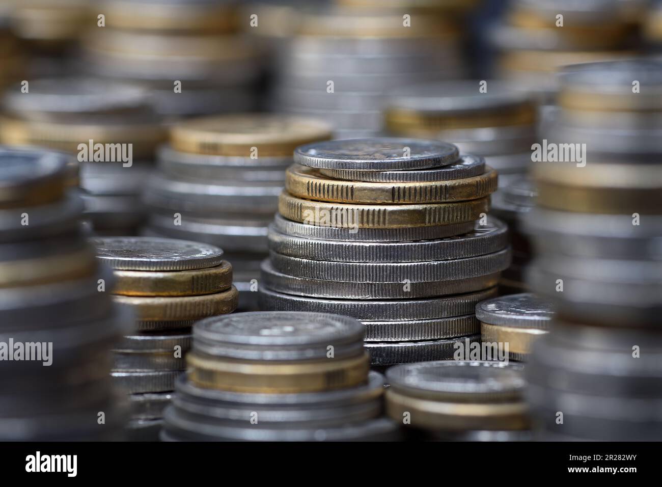 Ein Stapel gestapelter australischer Münzen für zwei und ein Dollar, fünfzig, zwanzig, zehn und fünf Cent füllt den Rahmen mit einem flachen Fokus bei sanfter Beleuchtung Stockfoto