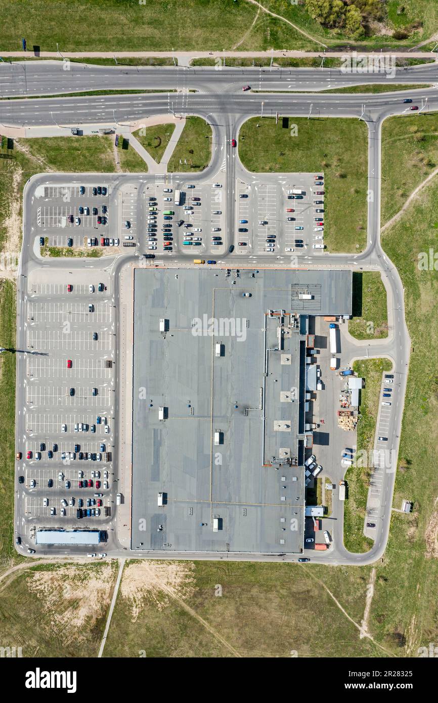 Draufsicht auf einen Parkplatz mit geparkten Autos in der Nähe des Supermarkts im Vorort Stockfoto