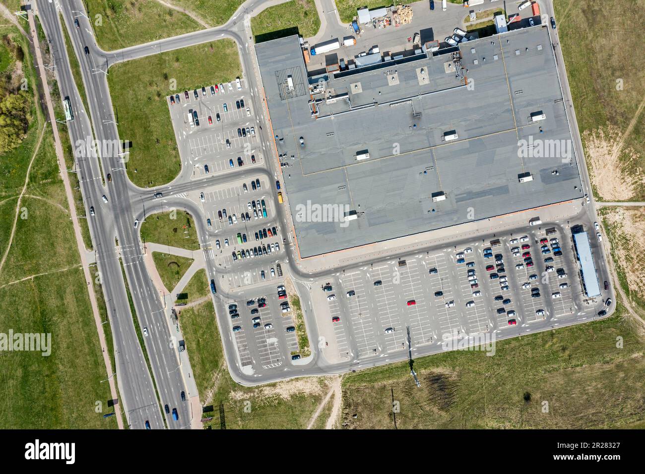 Blick von oben auf den Parkplatz des Einkaufszentrums mit nahe gelegenem Highway Stockfoto