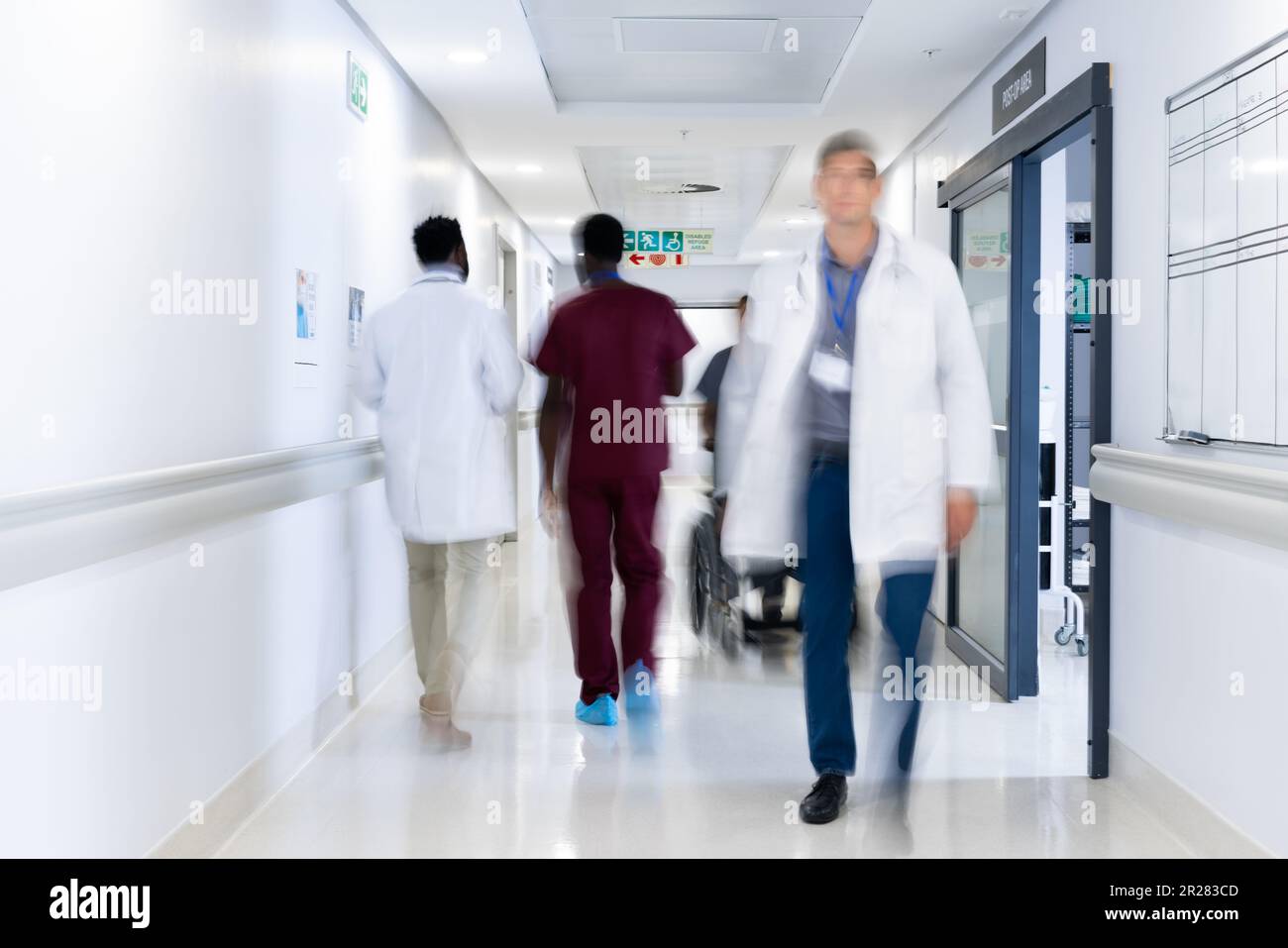 Verschwommene Bewegung verschiedener Ärzte und medizinischem Personal im belebten Krankenhausgang Stockfoto