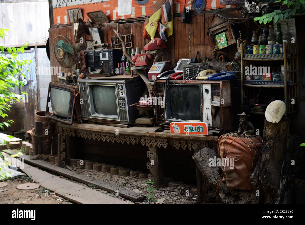 Alte Fernseher, Radios und Telefone, die vor einem Haus auf Koh Kret, Nonthaburi, Thailand ausgestellt wurden. Stockfoto
