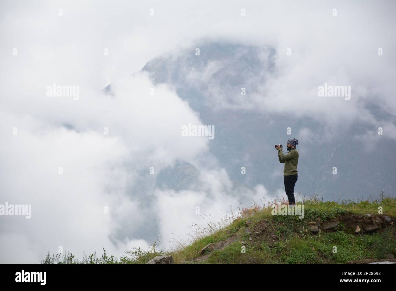 Auf der Suche nach der perfekten Aufnahme: Ein Fotograf nimmt die atemberaubende Aussicht von einem Berg auf. Stockfoto