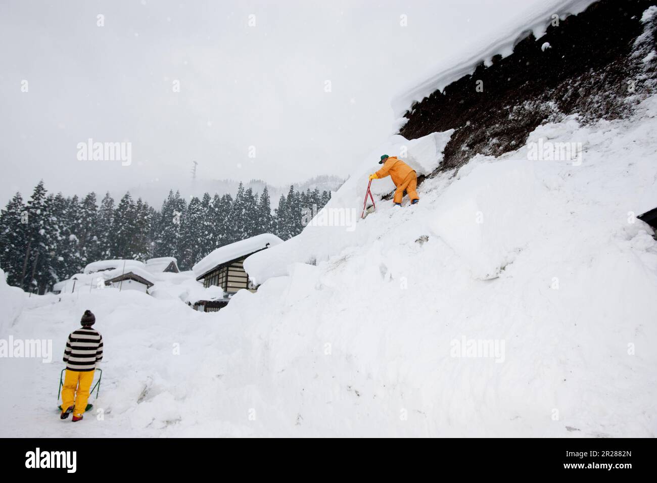 Schneeräumen vom Dach in Gokayama Gassho-zukuri Stockfoto