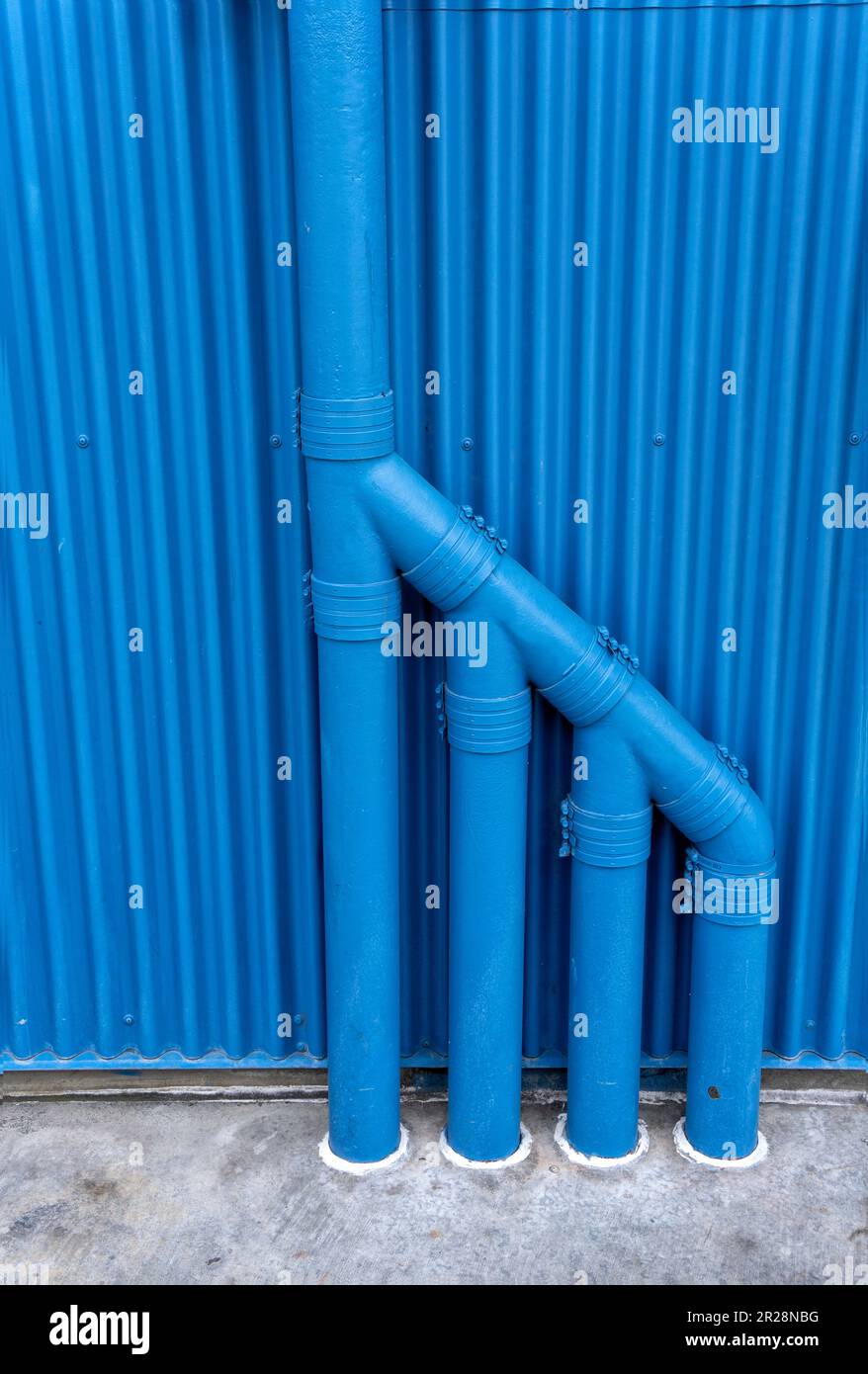 Blaue Rohre an Metallgleitwand Stockfoto