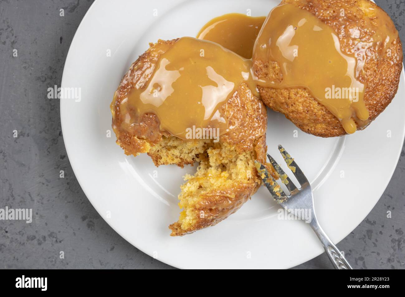 Mit Dulce de Leche beschichtete, einzeln gebackene Puddings - köstliche Karamellsauce Stockfoto