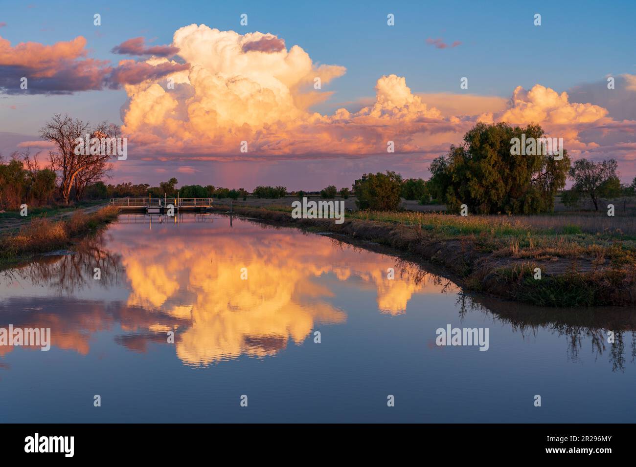 Farbige Sturmwolken, die sich in einem stillen Bewässerungskanal in der Nähe von St. George in Queensland, Australien Stockfoto