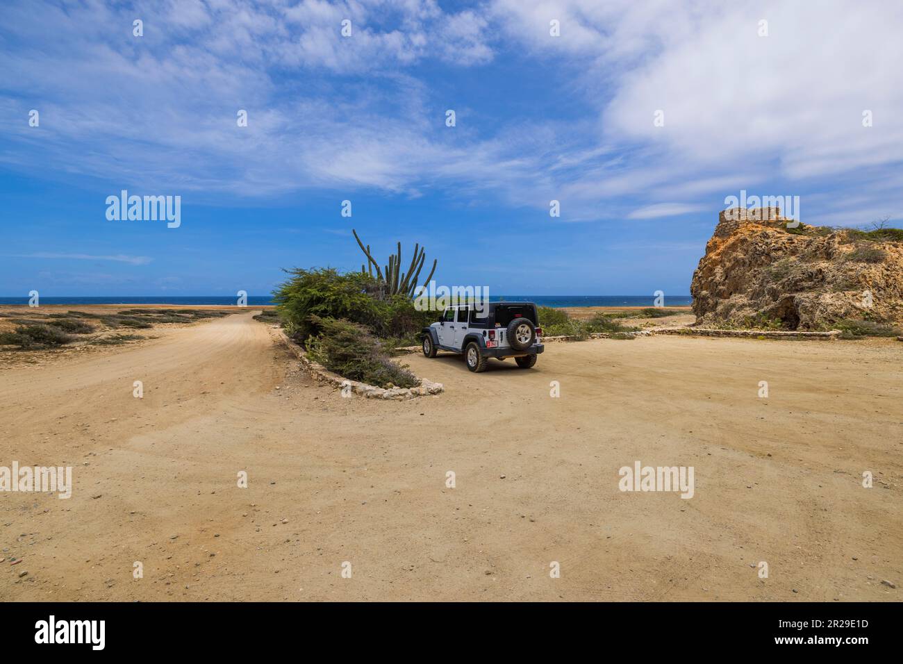 Wunderschöner Blick auf den Wrangler SUV auf dem Parkplatz des Arikok Nationalparks am Karibischen Meer. Aruba. Oranjestad. Stockfoto