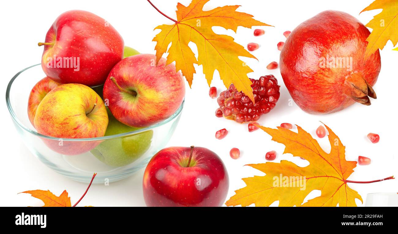 Äpfel, Granatapfelsamen und gelbe Ahornblätter isoliert auf weißem Hintergrund. Collage. Breites Foto. Stockfoto