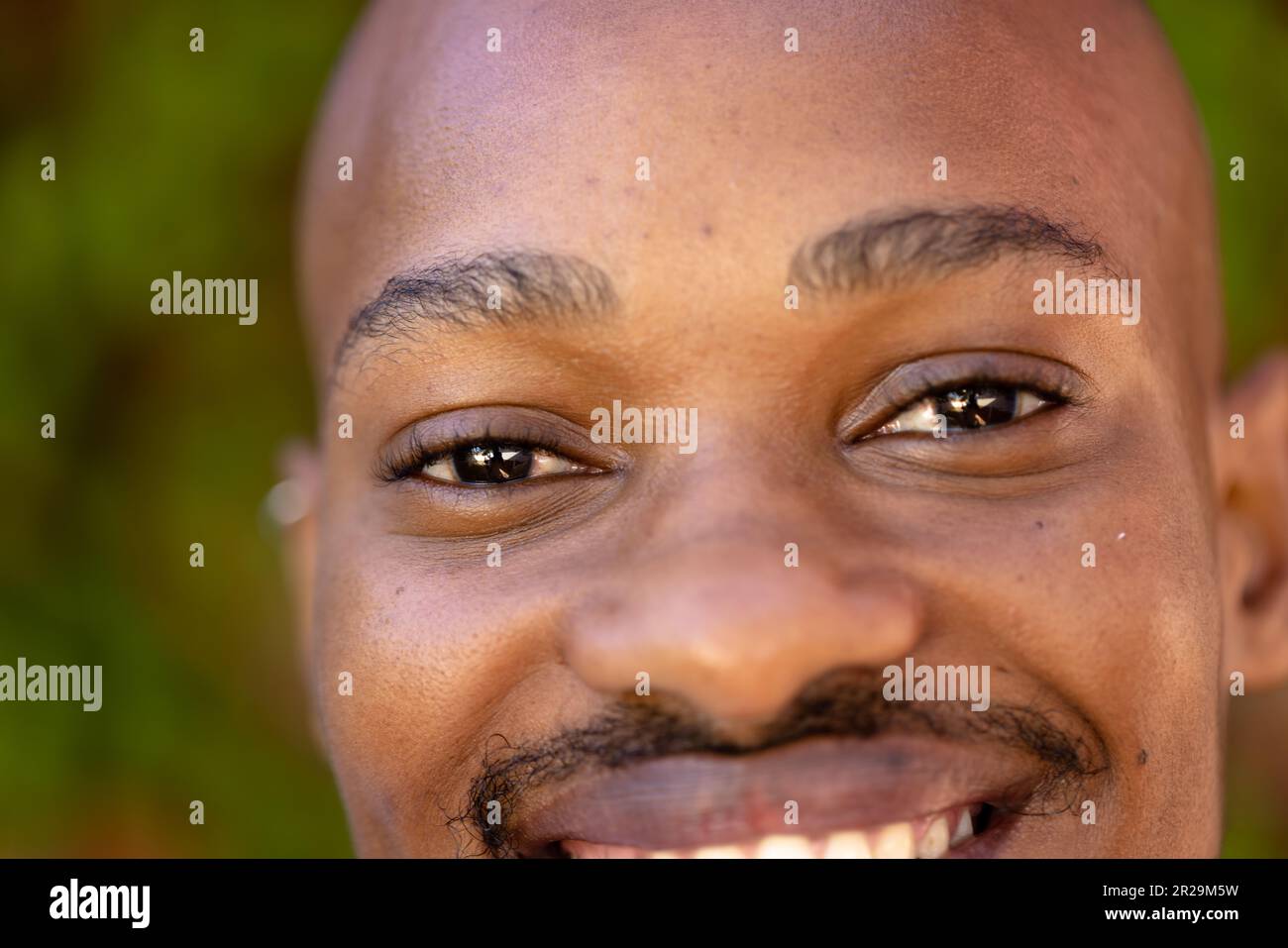 Nahaufnahme eines afroamerikanischen jungen Mannes mit schwarzen, lächelnden Augen Stockfoto