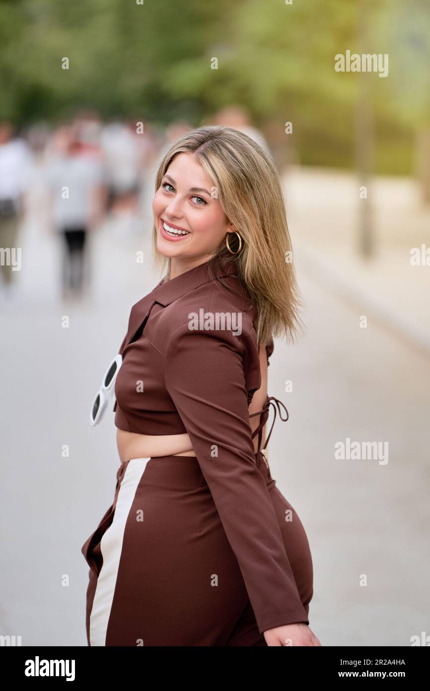 Wunderschöne junge blonde Frau, strahlende Schönheit, macht einen gemütlichen Spaziergang inmitten der Ruhe des Parks Stockfoto