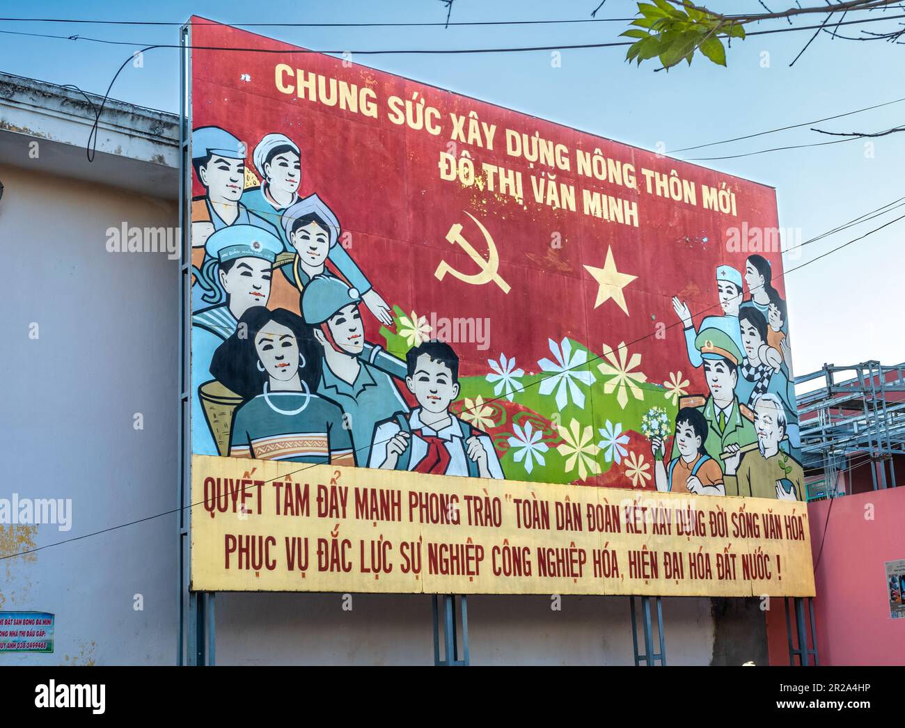 Eine Propaganda der Kommunistischen Partei Vietnams am Straßenrand, die alle Tyos der Menschen im Land lobt, um eine moderne Nation aufzubauen. Transla Stockfoto