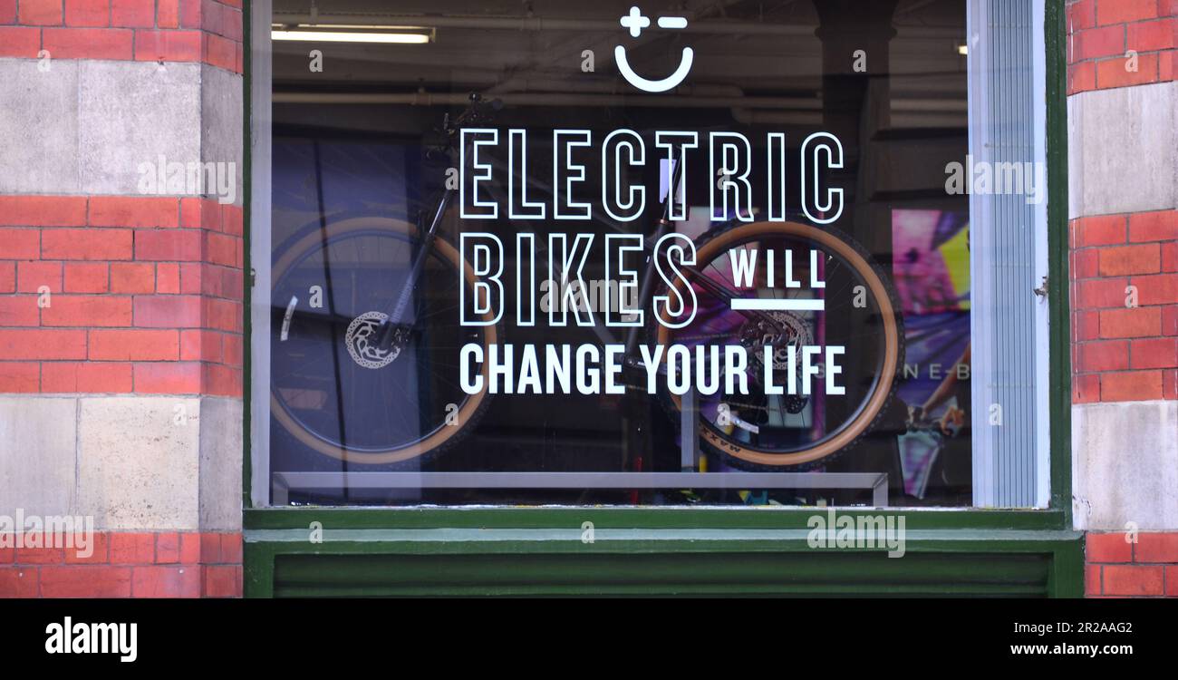 Schaufenster des Sign-on-Shops:' Electric Bikes will change your life', im Zentrum von Manchester, Großbritannien. Stockfoto