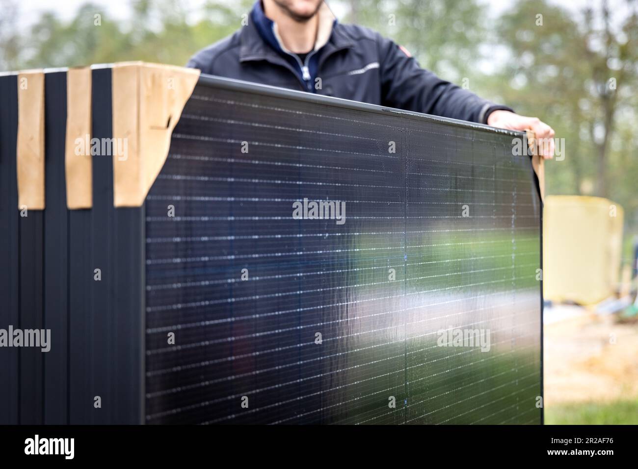 Person, die mehrere neue Solarpaneele hält Stockfoto