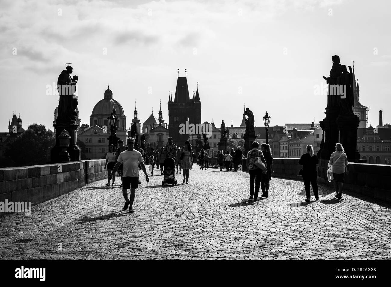 PRAG, TSCHECHISCHE REPUBLIK - 25. AUGUST 2022: Silhouetten von Touristen und Einheimischen über der berühmten Karlsbrücke in Prag, voll mit Touristen und Einheimischen Stockfoto