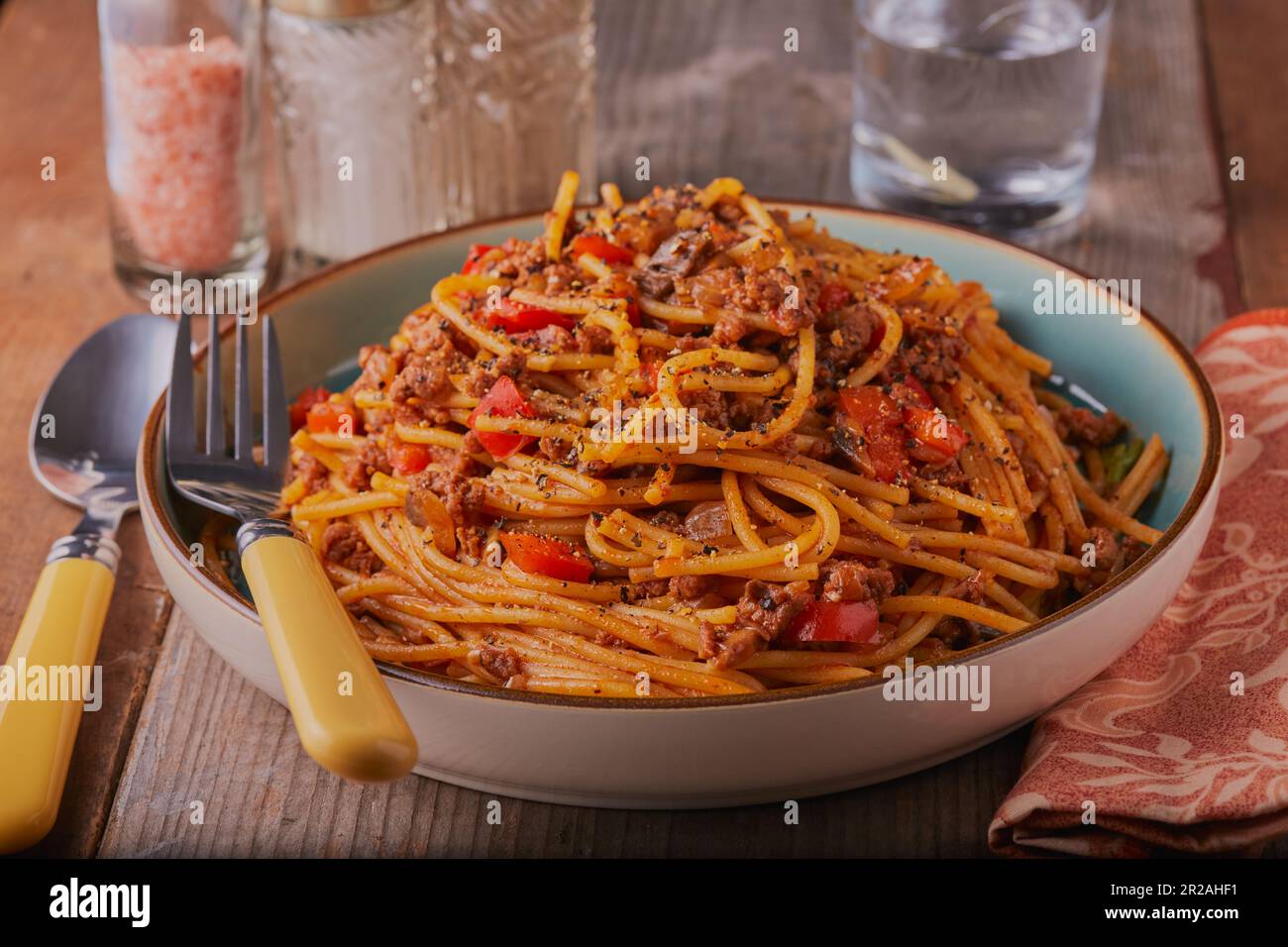 Teller mit Spaghetti Bolognese garniert mit Gewürzen und Kräutern. Stockfoto