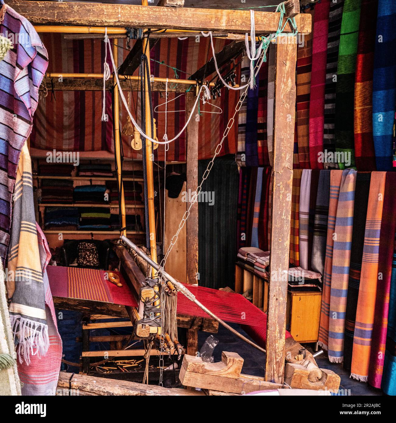 Einheimischer Handwerker, der traditionelle Rahmen nutzt und handgefertigte Textilien auf dem alten Kasbah-Markt kreiert. Marrakesch, Marokko Stockfoto