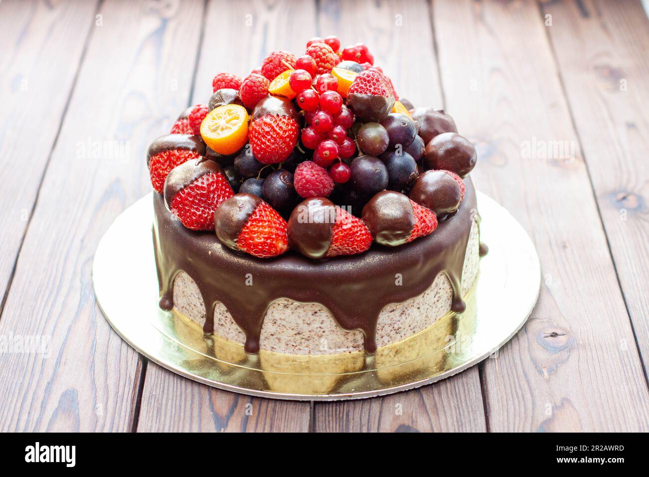 Reichhaltiger Schokoladen-Oreo-Kuchen mit Sauce und frischen Beeren, Erdbeere, Kirsche und Heidelbeere Stockfoto
