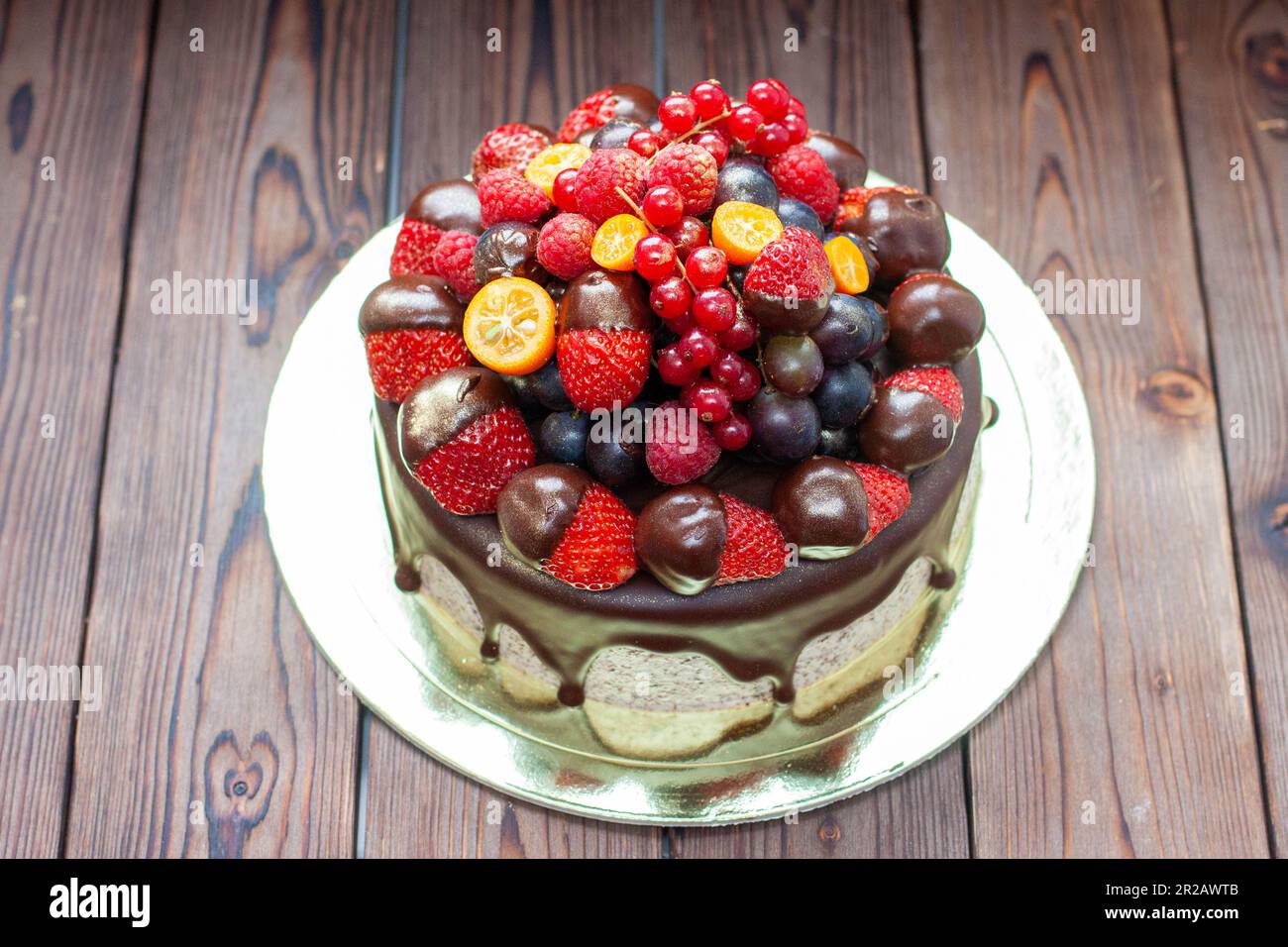 Reichhaltiger Schokoladen-Oreo-Kuchen mit Sauce und frischen Beeren, Erdbeere, Kirsche und Heidelbeere Stockfoto