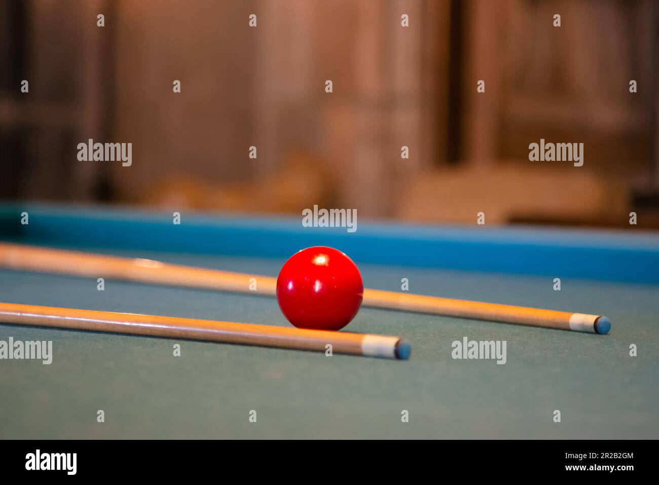 Roter Billardball mit Stichwort liegt auf einem grünen Billardtisch, Nahaufnahme. Billard Billardtisch im Retro-Stil Stockfoto