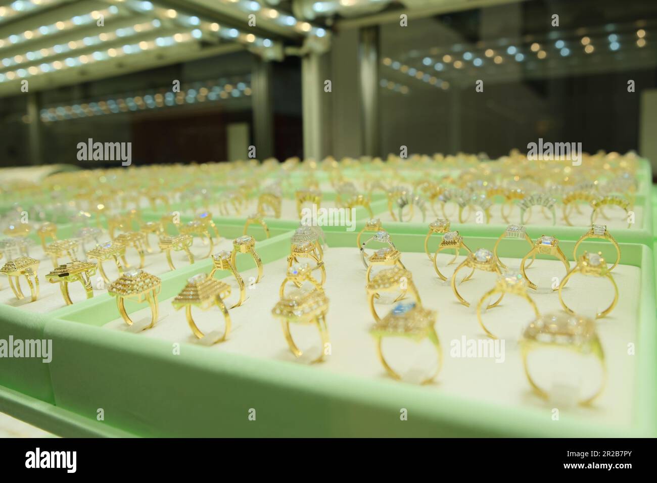 Goldene Diamanten-Verlobungsringe werden im Schaufenster des Einzelhandelsgeschäfts gezeigt. Stockfoto