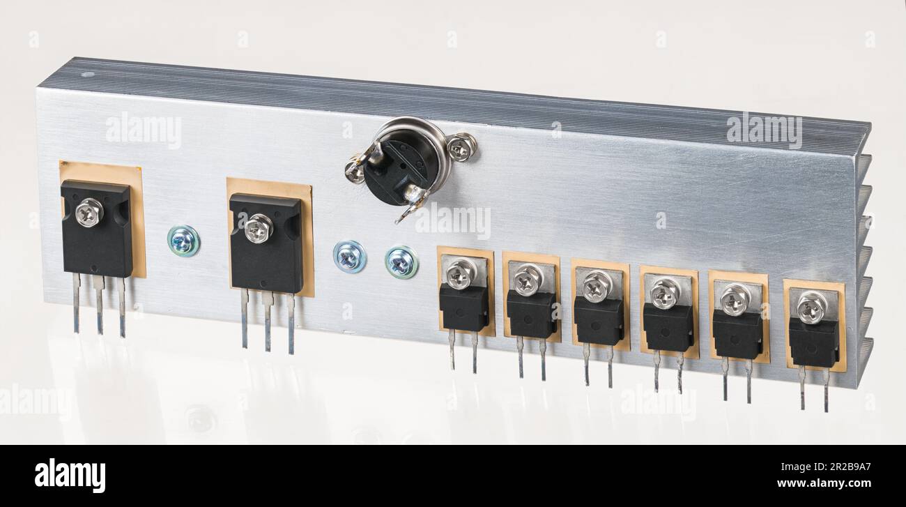 Elektronische Bauteile auf Aluminiumkühlkörper für geschaltete Stromversorgung auf weißem Hintergrund. Bipolare Transistoren, Dioden mit ultraschneller Soft Recovery. Kühler. Stockfoto