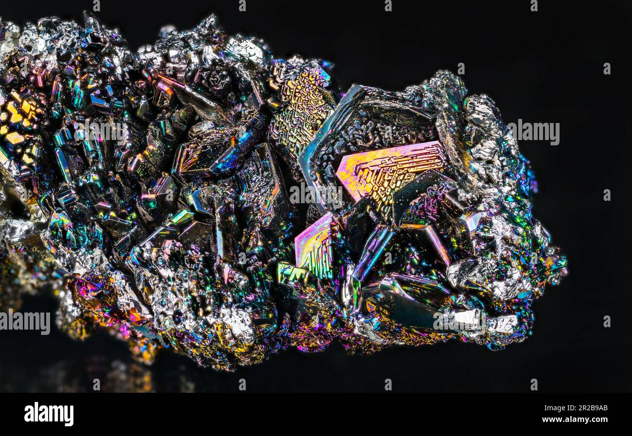 Nahaufnahme von schönen, bunten Siliziumkarbidkristallen auf schwarzem Hintergrund. Schillerndes synthetisches Carborund-Detail. Rohes Moissanit-Mineral. Wissenschaft. Stockfoto