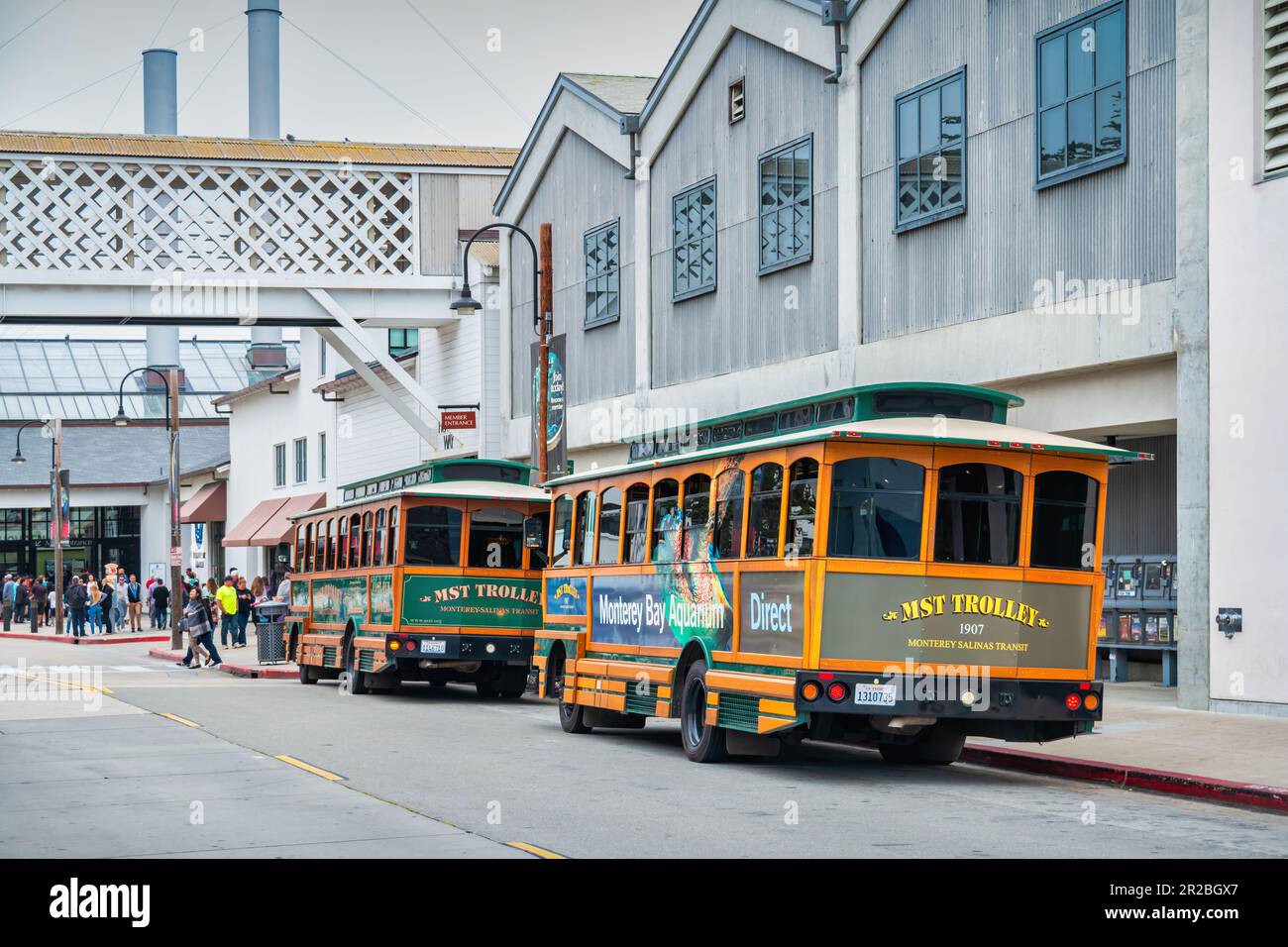 Klassische Trolleys in der Cannery Row Street in Monterey, CA, USA. Cannery Row war der Schauplatz von John Steinbecks Romanen, heute eine Touristenattraktion. Stockfoto