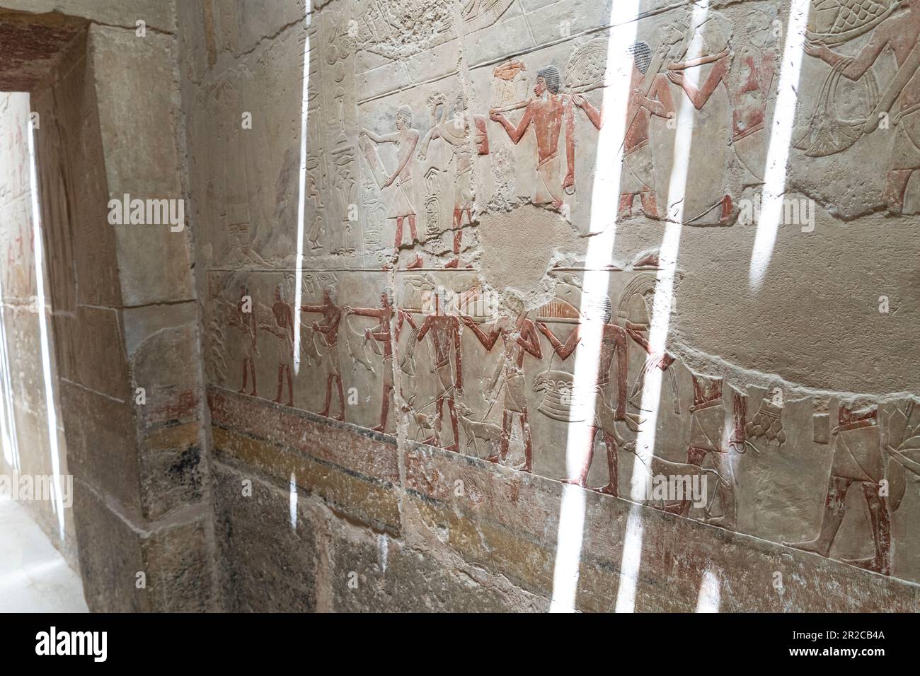 Alte ägyptische Farbbilder an der Wand im Grab. Große Schrittpyramide von Djoser, Sakkara. Kairo, Ägypten. Das Grab der Pharaonen. Altes ägyptisches Schreiben Stockfoto
