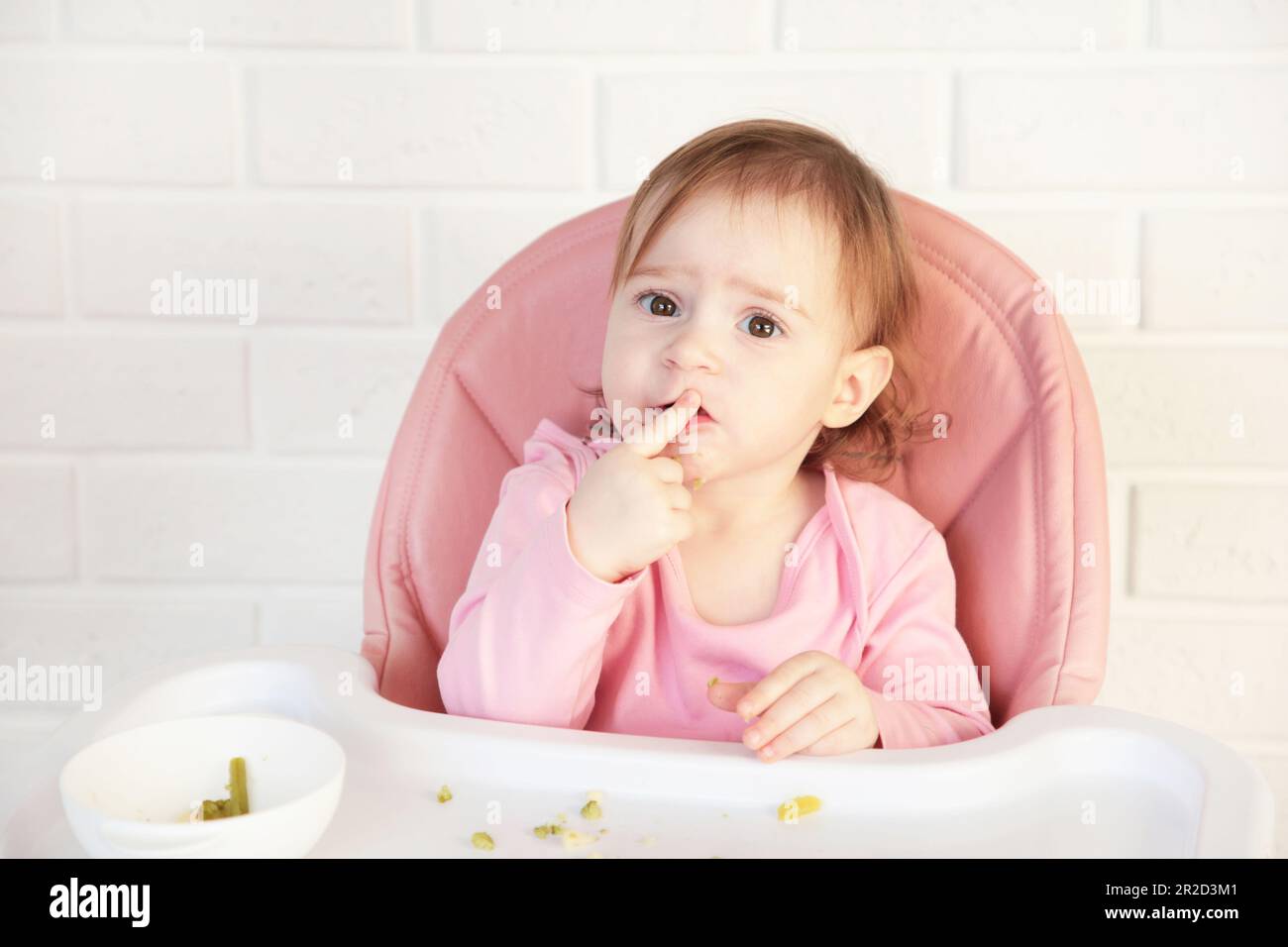 Ein kleines Mädchen, das ihr Essen isst und Chaos anrichtet. Draufsicht Stockfoto