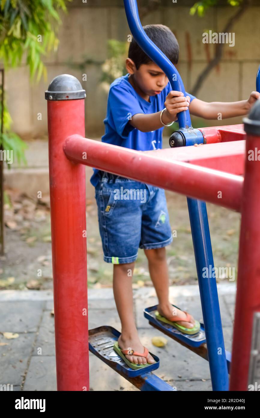 Asiatischer Junge, der morgens im Gesellschaftspark Routineübungen macht. Süße Bewegung und Fitness für kleine Kinder, um sich fit fürs Leben zu halten. Kinderarbeit Stockfoto